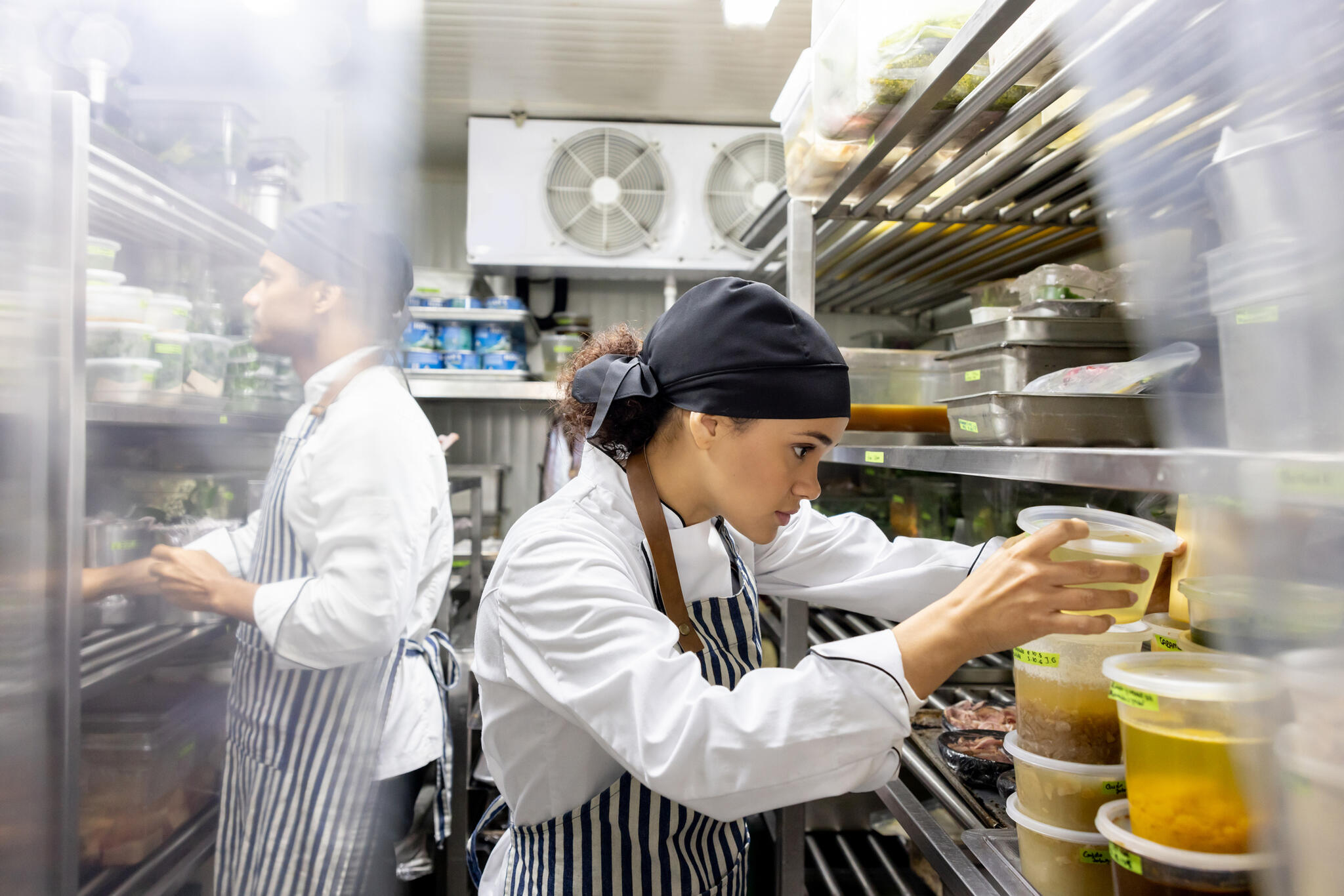 Two chefs inside commercial fridge